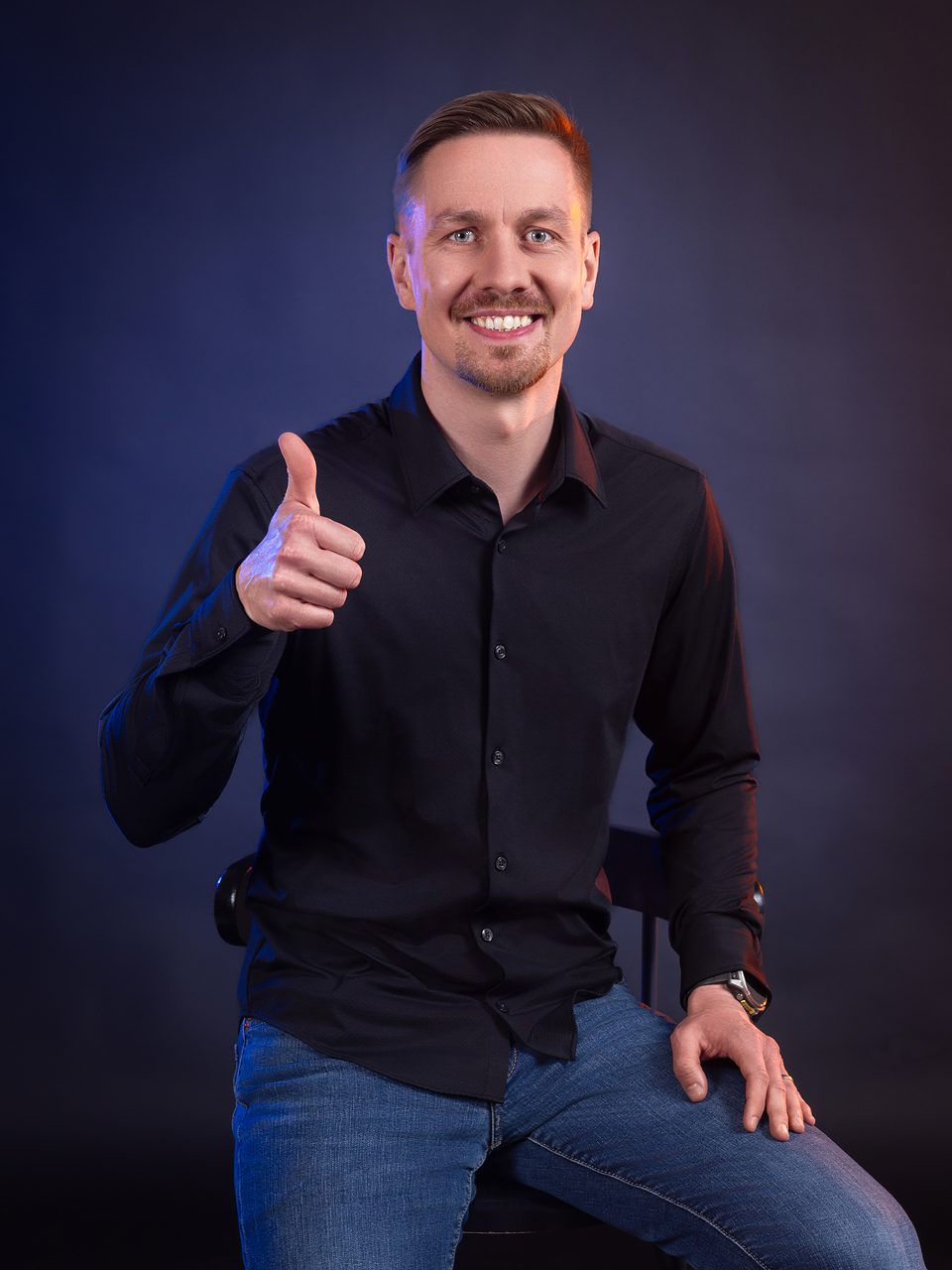 Jiří Ďoubek sedí na stoličce a s úsměvem ukazuje palec nahoru